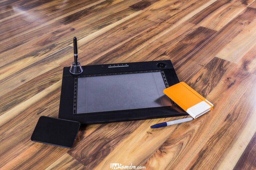 Traditional art vs digital art - Photo of a digital artist's setup with a tablet, stylus, and computer screen displaying art software